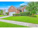 Beautiful brick house with lush green lawn, mature landscaping, and a sunny blue sky at 1868 Palmetto Isle Dr, Mount Pleasant, SC 29466