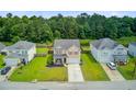 Aerial view of a well-maintained two-story home with a green lawn and a long driveway at 199 Meadow Wood Rd, Summerville, SC 29486