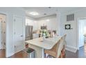 Bright kitchen features white cabinets, stainless steel appliances, and an island with marble countertop and wicker barstools at 21 George St # 203, Charleston, SC 29401