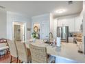 Bright kitchen features white cabinets, stainless steel appliances, and an island with marble countertop and wicker barstools at 21 George St # 203, Charleston, SC 29401