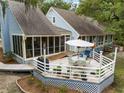 Expansive deck, accessible by ramp, offers ample space for dining and relaxation, complemented by the home's serene setting at 2653 Seabrook Island Rd, Seabrook Island, SC 29455
