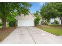 Traditional home with a spacious driveway, well-maintained lawn, and mature trees at 2845 August Rd, Johns Island, SC 29455