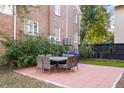 Outdoor patio with brick pavers, dining table set, grill, and landscaped surroundings at 301 Broad St # 1, Charleston, SC 29401