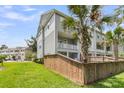 The townhome features a private balcony overlooking a well-maintained green space with lush palm trees at 348 Spindlewood Way, Charleston, SC 29414