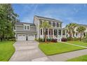 Charming two-story home boasts a welcoming front porch, manicured lawn, and a convenient three-car garage at 3739 Goodwater St, Mount Pleasant, SC 29466