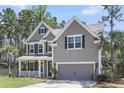 Attractive two-story home featuring a classic design, well-kept lawn, and attached garage at 404 Bowstring Dr, Huger, SC 29450