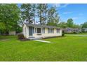 A cozy, single-level home with a vibrant green lawn, offering great curb appeal in a quiet neighborhood at 407 Raysor St, Saint George, SC 29477