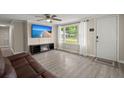 Inviting living room with wood-look floors, a ceiling fan, and a modern entertainment center with a fireplace at 407 Raysor St, Saint George, SC 29477