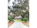 Picturesque home with a long driveway, lush landscaping, and a welcoming front porch at 4150 Nature View Cir, Johns Island, SC 29455
