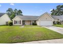 Inviting single-story home with manicured lawn, featuring a classic design and attached two-car garage at 432 Equinox Cir, Ladson, SC 29456