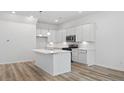 Bright kitchen features white cabinets, stainless steel appliances, and quartz countertops with a kitchen island at 4436 Oakwood Ave, North Charleston, SC 29405