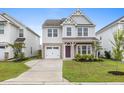 Charming two-story home with an attached garage, manicured lawn and inviting entrance at 514 Purple Finch Rd, Summerville, SC 29486