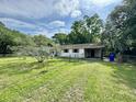 View of the home, framed by lush greenery, with a chain-link fence enclosing the well-manicured lawn at 524 Kell Pl, Charleston, SC 29412