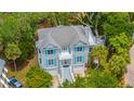 Aerial view of the home showcasing the light grey exterior, light blue shutters and mature trees at 5847 Back Bay Dr, Isle of Palms, SC 29451