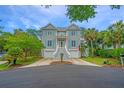 Charming grey two-story home with blue shutters and well-maintained landscaping at 5847 Back Bay Dr, Isle of Palms, SC 29451