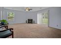 Bright living room with a cozy fireplace, large windows, and neutral carpet at 6231 Rolling Fork Rd # 1201-A, North Charleston, SC 29406