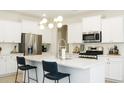 Modern kitchen features white cabinets, stainless steel appliances, an island, and bar stool seating at 69 Red Bluff St, Summerville, SC 29483