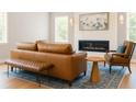 Stylish living room with leather sofa, fireplace, modern lighting, and a patterned blue rug at 69 Red Bluff St, Summerville, SC 29483