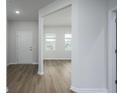 Bright foyer featuring wood-look flooring, white walls, and views of the living area through an arched doorway at 758 Meadowbrook Lane, Summerville, SC 29486