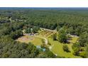 Expansive aerial view of lush, wooded property with a pond, orchard, and various buildings adding to its charm at 806 Appii Rd, Moncks Corner, SC 29461