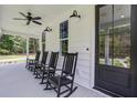 Inviting front porch with classic black rocking chairs and stylish lighting fixtures at 105 Bobcat Ln, Ravenel, SC 29470