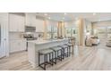 Modern kitchen features an island with seating, stainless steel appliances, white cabinets, and lots of natural light at 109 Indigo Cove Blvd, Summerville, SC 29486