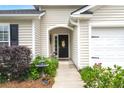 Inviting front entrance with black door, adorned with decorative accents and complemented by landscaped walkway at 1103 Cates Ct, Summerville, SC 29483