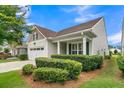 Beautiful single-Gathering home showcasing a well-manicured lawn, lush shrubs, and a welcoming covered porch at 117 Harbor Trace Ln, Summerville, SC 29486