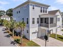 Rear exterior showcasing a three-story home with a screened in porch and two-car garage at 1182 Welcome Dr Dr, Mount Pleasant, SC 29464