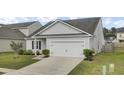 Well-maintained single-Gathering home showcasing a driveway leading to a two-car attached garage at 121 Ancestry Ln, Moncks Corner, SC 29461