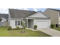 Beautiful single-story home featuring a well-kept lawn, small tree, and an attached two-car garage at 121 Ancestry Ln, Moncks Corner, SC 29461