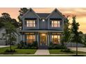 Beautiful two-story home featuring an inviting front porch with manicured lawn under a dramatic evening sky at 125 Integrity Ln, Charleston, SC 29492
