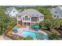 Stunning aerial view showcasing a private pool, deck, screened porch, and well-manicured landscaping at 1308 Divot Ct, Mount Pleasant, SC 29466