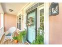 Inviting front porch featuring a rocking chair, potted plants, and a decorative wreath on the door at 1308 Divot Ct, Mount Pleasant, SC 29466