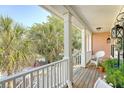 Relaxing porch featuring white railings, rocking chairs, and a scenic view of palm trees and neighborhood at 1308 Divot Ct, Mount Pleasant, SC 29466