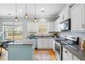 Modern kitchen with white cabinets, stainless steel appliances, a center island, and stylish pendant lighting at 1458 Clarendon Way, Mount Pleasant, SC 29466