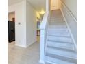 Bright entryway with a staircase featuring white risers and hallway leading to kitchen with stainless appliances at 149 Woodward Rd, Goose Creek, SC 29445