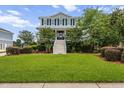 Charming two-story home with a lush front lawn, a grand staircase entrance and mature landscaping at 1597 Rivertowne Country Club Dr, Mount Pleasant, SC 29466