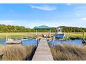 Picturesque dock with a covered seating area extending into a tranquil marsh at 1635 Bull Creek Ln, Charleston, SC 29414