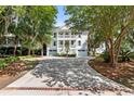 Charming two-story home with a spacious driveway and a double front porch surrounded by lush landscaping at 1635 Bull Creek Ln, Charleston, SC 29414