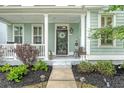 Inviting front porch featuring classic columns, a welcome sign, and beautiful landscaping at 1822 Grovehurst Dr, Charleston, SC 29414