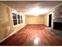 Bright living room featuring hardwood floors, a brick fireplace, and large windows for natural light at 1871 Grimball Rd, Charleston, SC 29412