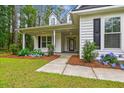 Inviting front entrance with a covered porch, beautiful hydrangeas, and manicured landscaping at 206 Almond Ct, Summerville, SC 29483