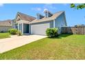 A bright blue home with a white garage door and mature landscaping at 224 Sugarhouse Ct, Moncks Corner, SC 29461