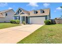 Charming blue home with manicured landscaping, dormers, and a two-car garage at 224 Sugarhouse Ct, Moncks Corner, SC 29461