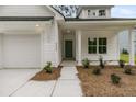 Close-up of home's entrance features a teal front door, neat landscaping, and an attached garage at 3222 Pinewood Dr, Ladson, SC 29456