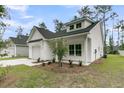 Inviting one-story home with white siding, black roof, manicured lawn, and an attached garage at 3222 Pinewood Dr, Ladson, SC 29456
