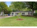 Inviting single-story home showcasing a green lawn, mature trees, and classic American flag at 344 Lantana Dr, Charleston, SC 29407