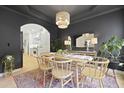 Stylish dining room boasts dark walls, a unique chandelier, and a view into the bright kitchen at 3520 E Higgins Dr, Mount Pleasant, SC 29466