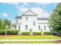 Side view of a white two-story home with a manicured lawn and lush landscaping, showcasing its classic design at 3707 Gambrill Ln, Mount Pleasant, SC 29466